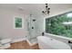 Bathroom featuring a standalone tub, glass shower, and stylish black fixtures at 858 Pates Creek Rd, Stockbridge, GA 30281