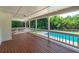 Covered back porch showcasing a wooden deck floor with view of swimming pool and trees at 858 Pates Creek Rd, Stockbridge, GA 30281