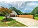 Exterior view of home featuring a garage, a wooden fence, and mature landscaping at 858 Pates Creek Rd, Stockbridge, GA 30281