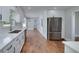 Modern kitchen featuring sleek white cabinetry, stainless steel appliances, and hardwood floors for a bright and inviting cooking space at 858 Pates Creek Rd, Stockbridge, GA 30281