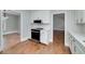 Well-appointed kitchen with white cabinets, stainless steel appliances, and hardwood floors, seamlessly connecting to the adjacent dining area at 858 Pates Creek Rd, Stockbridge, GA 30281