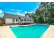Backyard pool area with lush landscaping, fenced yard, and a covered deck at 858 Pates Creek Rd, Stockbridge, GA 30281