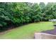 Spacious backyard with manicured lawn and mature trees, enclosed by a fence for privacy and security at 1404 Fairwinds Ct, Loganville, GA 30052