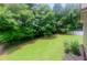 A lush, green backyard offers a serene setting with mature trees and manicured lawn at 1404 Fairwinds Ct, Loganville, GA 30052