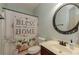 Bathroom featuring a patterned shower curtain, dark cabinets, and a circular mirror at 1404 Fairwinds Ct, Loganville, GA 30052
