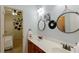 Bathroom with double sink vanity, cherry cabinets, and connection to bedroom at 1404 Fairwinds Ct, Loganville, GA 30052