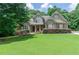 Charming two-story home features a well-manicured lawn, lush landscaping, and inviting entrance with covered front porch at 1404 Fairwinds Ct, Loganville, GA 30052