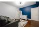 Cozy sitting room features a modern light fixture, blue accent wall, and stylish gray sofa at 1404 Fairwinds Ct, Loganville, GA 30052