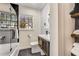 Modern bathroom featuring black hexagon tile floors, a decorative accent wall, and a tub/shower combo at 1471 Hardin Dr, College Park, GA 30337