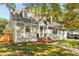 Exterior view of the home featuring a charming walkway, gray siding, and mature landscaping at 1471 Hardin Dr, College Park, GA 30337