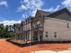 A row of newly constructed townhouses with brick exteriors under a blue sky at 3232 Cyrus Creek Dr, Kennesaw, GA 30152