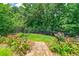 Serene backyard scene with a stone stairway leading to an upper level, surrounded by flowering plants at 825 Chalet Hls, Mcdonough, GA 30253
