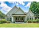 Backyard view featuring a covered patio with outdoor seating, lush green lawn, and mature landscaping at 825 Chalet Hls, Mcdonough, GA 30253