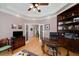 This home office features built in shelving, hardwood floors, and many windows at 825 Chalet Hls, Mcdonough, GA 30253