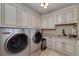 Bright laundry room with ample storage, sink and modern washer and dryer at 825 Chalet Hls, Mcdonough, GA 30253