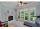 Light filled sitting area features a fireplace, large windows, and a ceiling fan at 825 Chalet Hls, Mcdonough, GA 30253