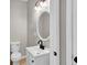 Charming bathroom featuring a white vanity, an oval mirror and modern lighting fixtures at 583 Whitaker St, Atlanta, GA 30318