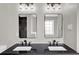 Modern bathroom featuring a black granite countertop with dual sinks and mirrors, alongside elegant lighting at 583 Whitaker St, Atlanta, GA 30318