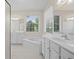 Bright bathroom featuring a soaking tub, double sinks and white cabinetry at 5831 Wembley Dr, Douglasville, GA 30135