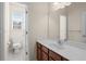 Well-lit bathroom boasts wood cabinets, a large mirror and a window at 5831 Wembley Dr, Douglasville, GA 30135