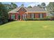 Charming single-story brick home featuring a lush green lawn, manicured shrubs, and inviting curb appeal at 5831 Wembley Dr, Douglasville, GA 30135