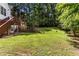 The backyard has lush green grass, with mature trees, and a wooden fence at 6280 Autry Mill Rd, Cumming, GA 30028