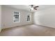 Spacious bedroom featuring neutral carpet, a ceiling fan, and large windows at 6280 Autry Mill Rd, Cumming, GA 30028