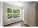 Bright dining area with a large window, wood-look flooring, and storage cabinet at 6280 Autry Mill Rd, Cumming, GA 30028