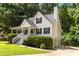 Angle view of the attractive home with a side entry garage, chimney, and mature trees at 6280 Autry Mill Rd, Cumming, GA 30028