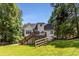 Exterior back of home with deck, stairs, and lush greenery at 6280 Autry Mill Rd, Cumming, GA 30028