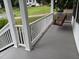 Inviting front porch featuring a gray deck, white railing and a relaxing swing at 6280 Autry Mill Rd, Cumming, GA 30028