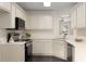 A well-lit kitchen featuring white cabinetry, stainless steel appliances, and wood-look floors at 6280 Autry Mill Rd, Cumming, GA 30028