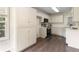 Well-lit kitchen featuring white cabinets, stainless steel appliances, and wood-look flooring at 6280 Autry Mill Rd, Cumming, GA 30028