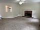 Spacious living room features neutral carpet, a fireplace, and view into kitchen at 6280 Autry Mill Rd, Cumming, GA 30028
