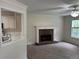 Cozy living room features a brick fireplace, ceiling fan, and view to kitchen at 6280 Autry Mill Rd, Cumming, GA 30028