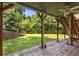 Covered patio area with brick flooring, wooden posts, ceiling fan, and stairs to backyard at 6280 Autry Mill Rd, Cumming, GA 30028