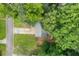 Aerial view of home with driveway, lawn and dense tree coverage at 6441 Michell Way, Douglasville, GA 30135
