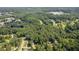 Expansive aerial view of a property nestled amongst lush greenery and mature trees, near a tranquil lake at 6441 Michell Way, Douglasville, GA 30135