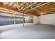 Spacious unfinished basement with exposed ceiling, concrete floor, and garage doors at 6441 Michell Way, Douglasville, GA 30135