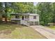 Charming home featuring a welcoming porch, two car garage and mature trees at 6441 Michell Way, Douglasville, GA 30135