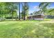 A large grassy backyard with mature trees surrounds a single-story brick home, offering privacy at 6671 Gano Dr, Riverdale, GA 30274