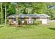 Charming single-story brick home with a well-manicured lawn, mature tree and an attached single car garage at 6671 Gano Dr, Riverdale, GA 30274