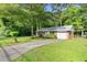 Well-maintained single story brick home with long driveway and lush green lawn in a wooded setting at 6671 Gano Dr, Riverdale, GA 30274