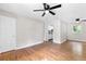 Bright living room with hardwood floors, gray walls, ceiling fan, and view into adjacent kitchen at 6671 Gano Dr, Riverdale, GA 30274