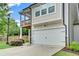 Exterior of home with white garage door, second story deck, and stone accents at 1858 Belmore Se St, Smyrna, GA 30080
