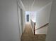 Bright hallway featuring a light-colored carpet and wood banister leading to other rooms in the home at 2670 Henderson Chase Ct, Tucker, GA 30084