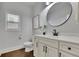 Modern bathroom with a sleek vanity, round mirror, and stylish fixtures at 3940 Frasier Dr, Cumming, GA 30028