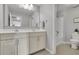 Well-lit bathroom with double sinks, a large mirror, and modern fixtures at 3940 Frasier Dr, Cumming, GA 30028