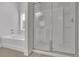 Well-lit bathroom showcasing a soaking tub, glass-enclosed shower, and neutral decor at 3940 Frasier Dr, Cumming, GA 30028