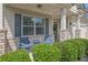 Charming front porch area with seating, brick accents, and manicured landscaping at 3940 Frasier Dr, Cumming, GA 30028